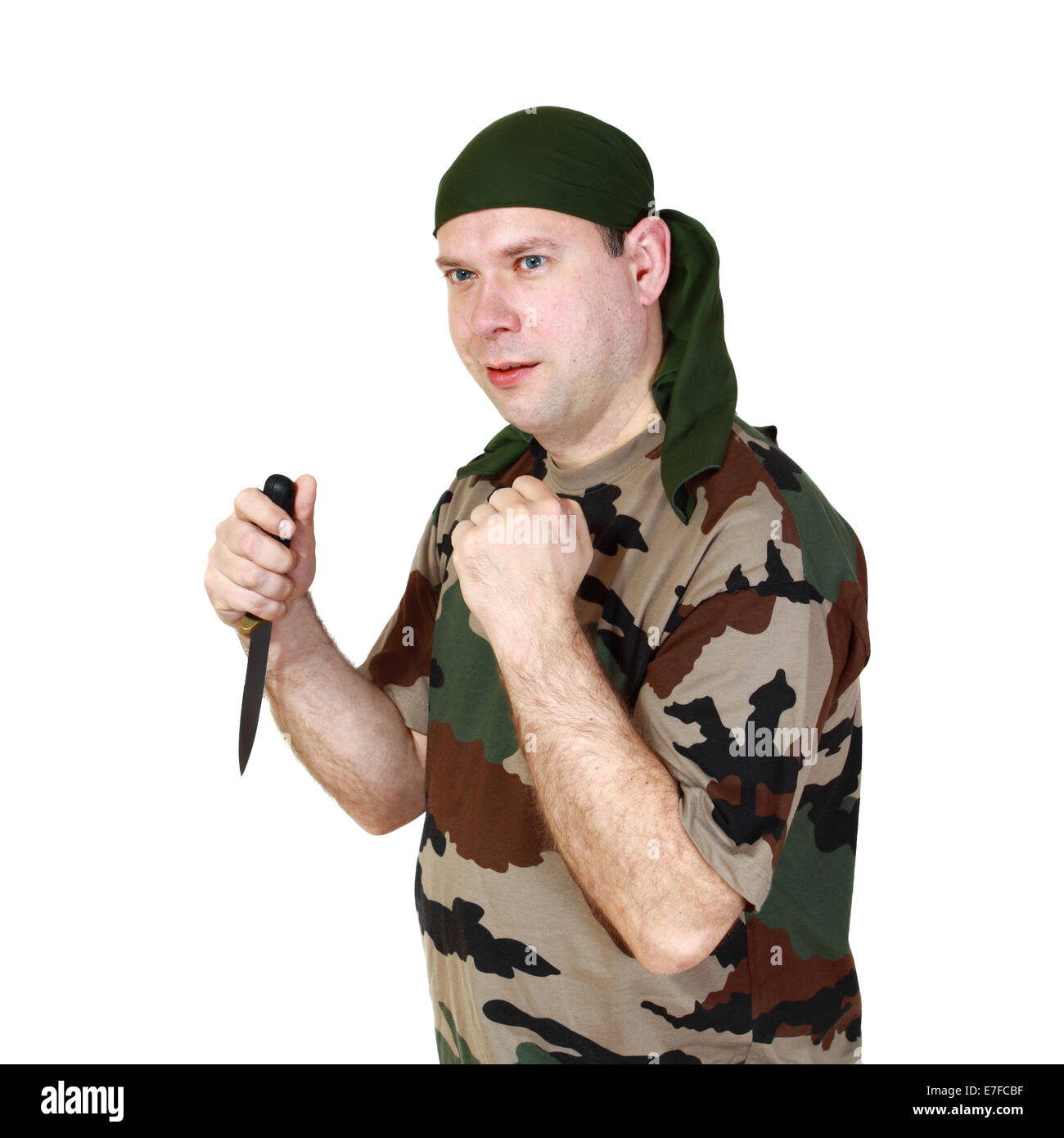 Man in camouflage with knife in hand stands in a fighting stance. Isolated on white background Stock Photo