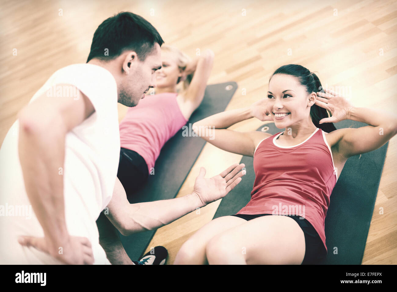 group of smiling women doing sit ups in the gym Stock Photo