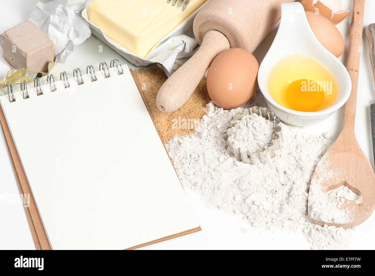 recipe book and baking ingredients eggs, flour, sugar, butter, yeast. food background Stock Photo