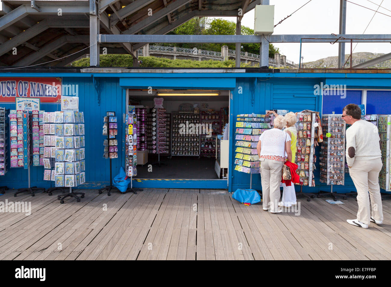 Llandudno Pier North Wales, Tourists looking at fridge magnates outside novelty  gift store Stock Photo