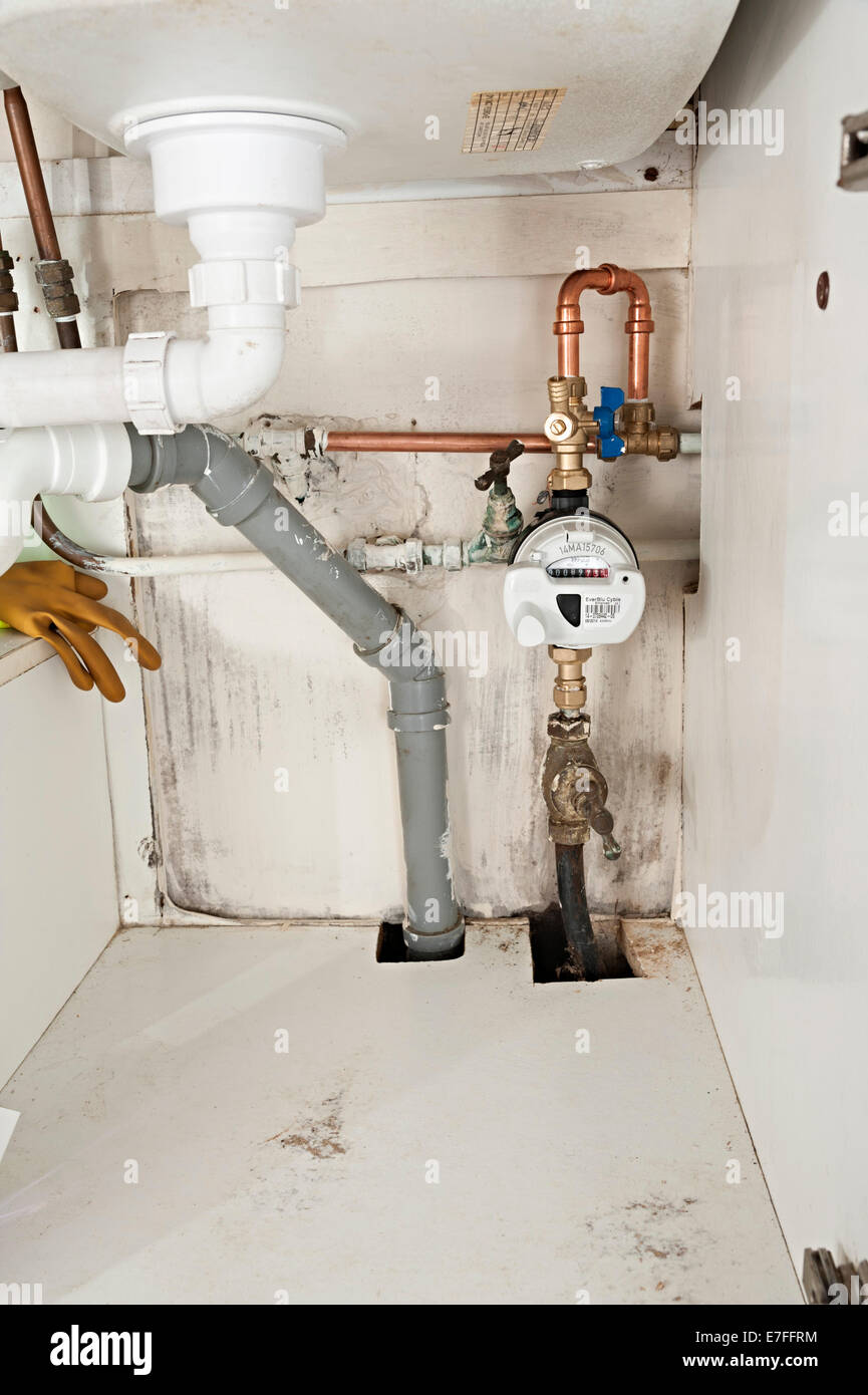 a water meter under a domestic sink with moldy walls the uk these meters have radio signals for collecting readings for Severn Stock Photo