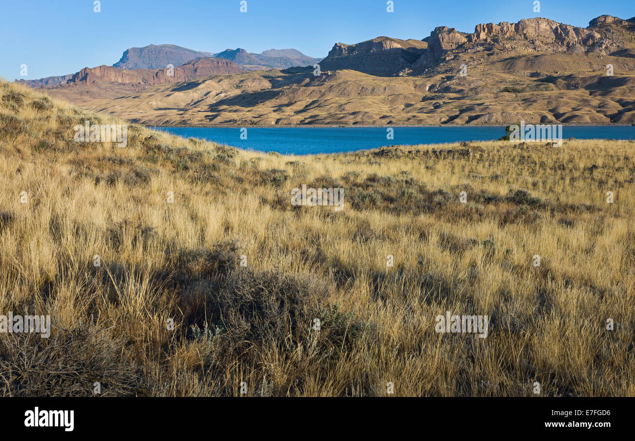 Buffalo Bill reservoir flanked by scrub land and rocky mountains at dawn near the town of Cody, Wyoming, USA Stock Photo