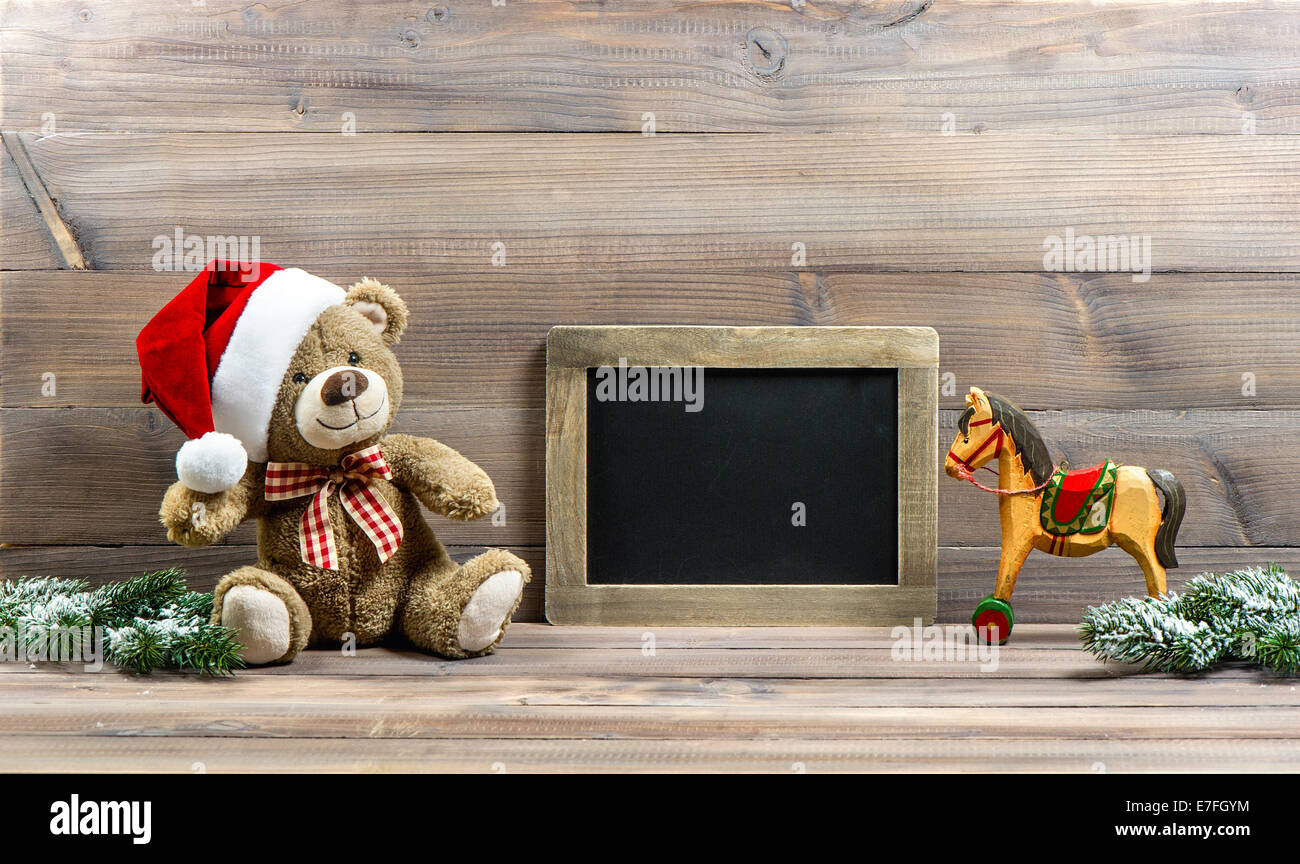 nostalgic christmas decoration with antique toys teddy bear and wooden rocking horse. Stock Photo