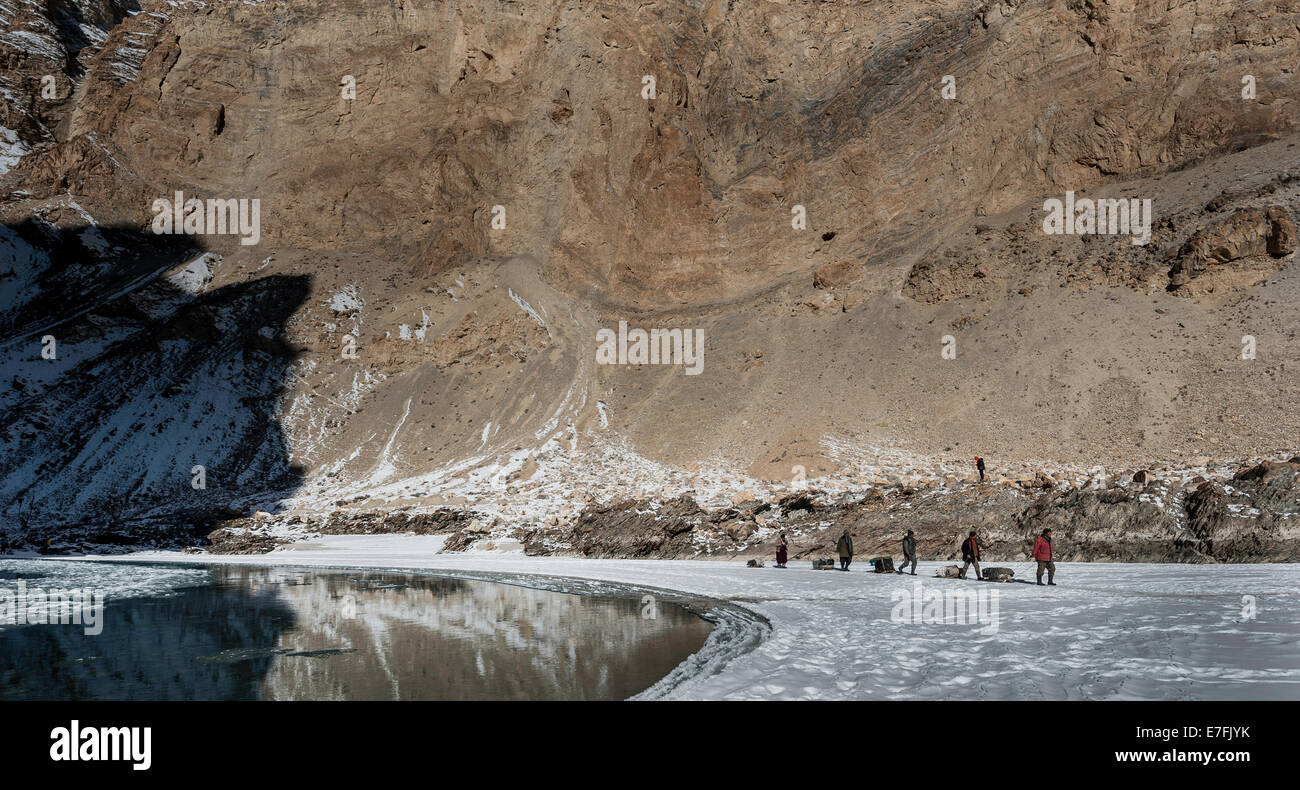 Group of porters are walking on the frozen Zanskar River, during Chadar Trek. Stock Photo