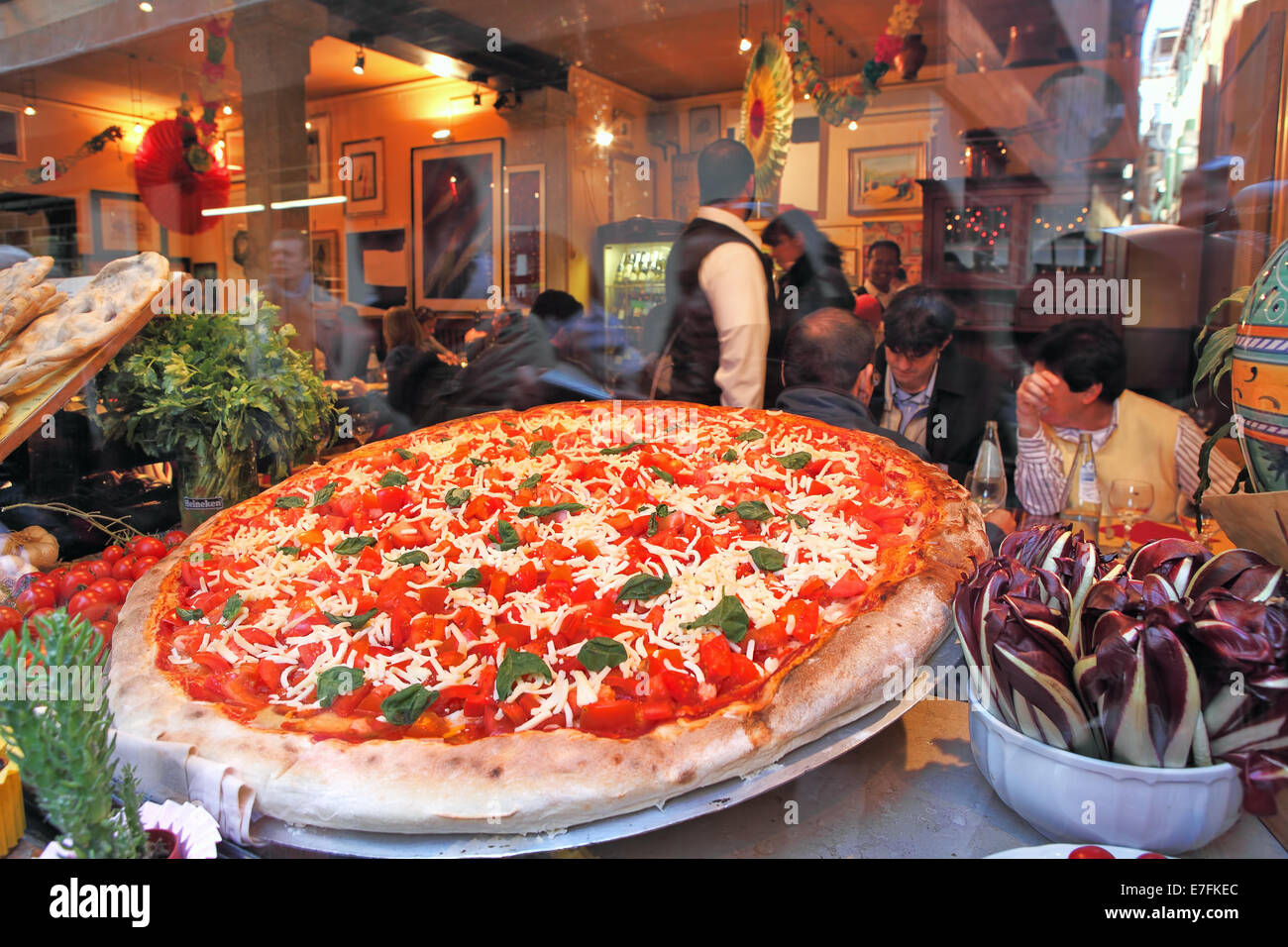 Big round plate of pizza with red tomatoes and cheese. Stock Photo