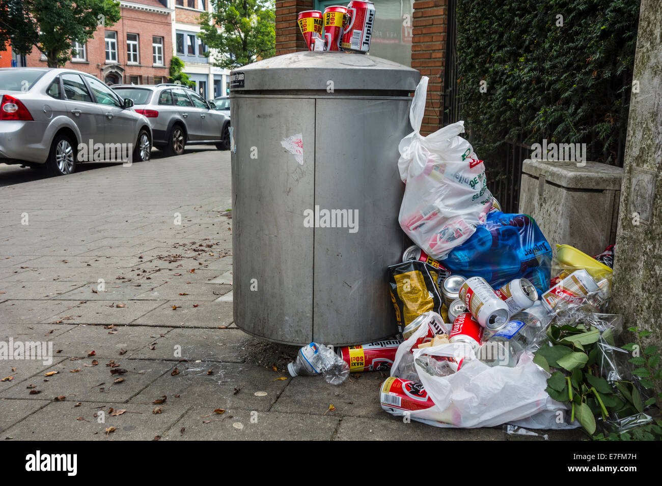 https://c8.alamy.com/comp/E7FM7H/overfull-rubbish-bin-garbage-can-with-trash-around-and-beer-cans-piled-E7FM7H.jpg