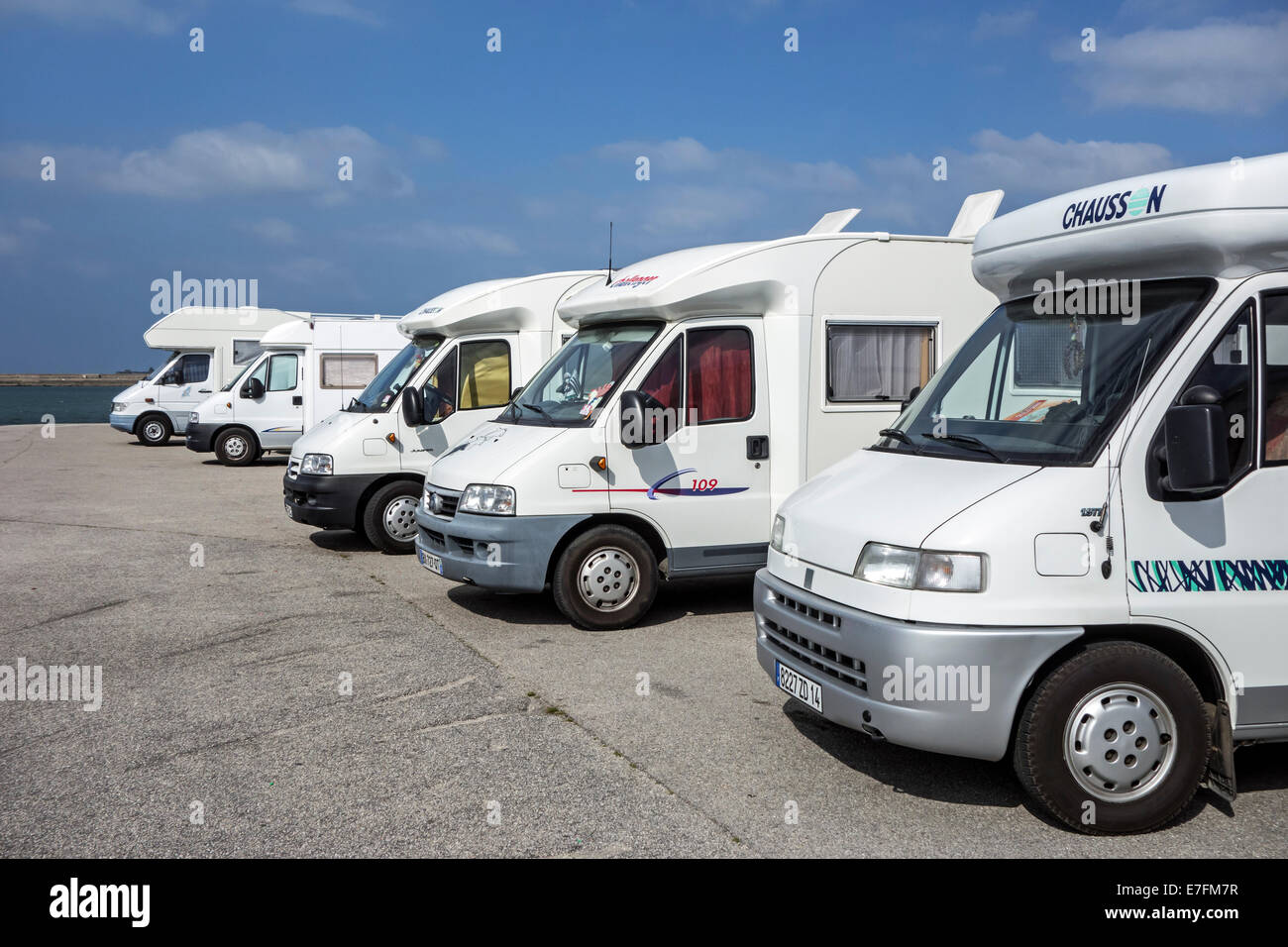 Row of motorhomes parked in car park for RVs / recreational vehicle along the coast with view over the sea Stock Photo