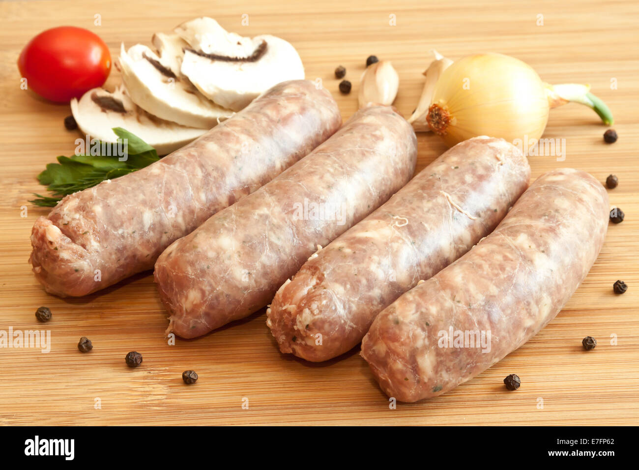 Uncooked sausages with vegetables on the chopping board Stock Photo Alamy