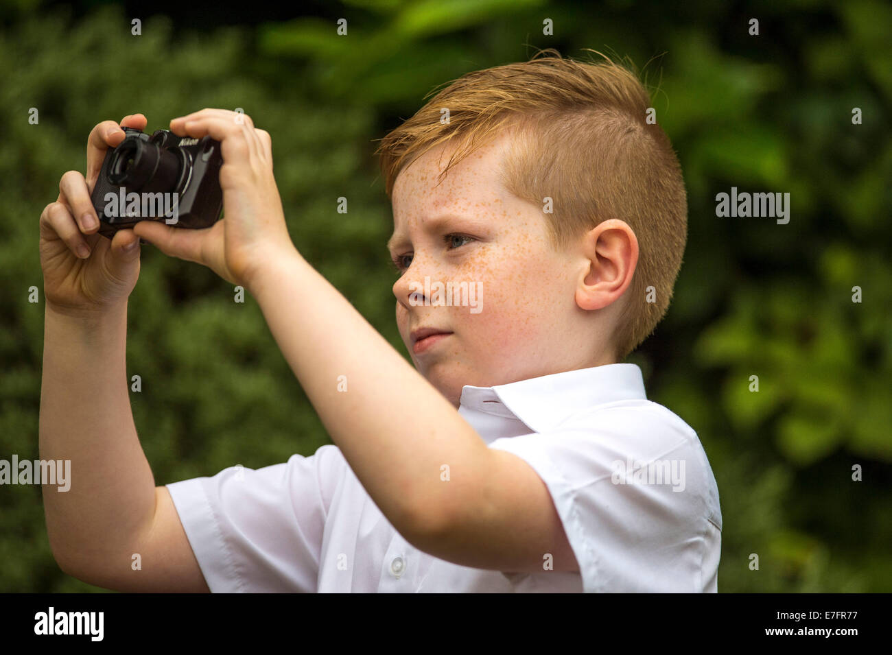 Young boy taking a photograph with a Nikon Coolpix digital camera. Stock Photo