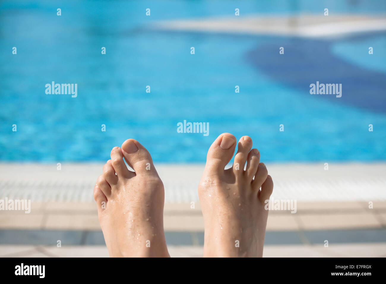 Feet of young caucasian woman laying by swimming pool Stock Photo - Alamy