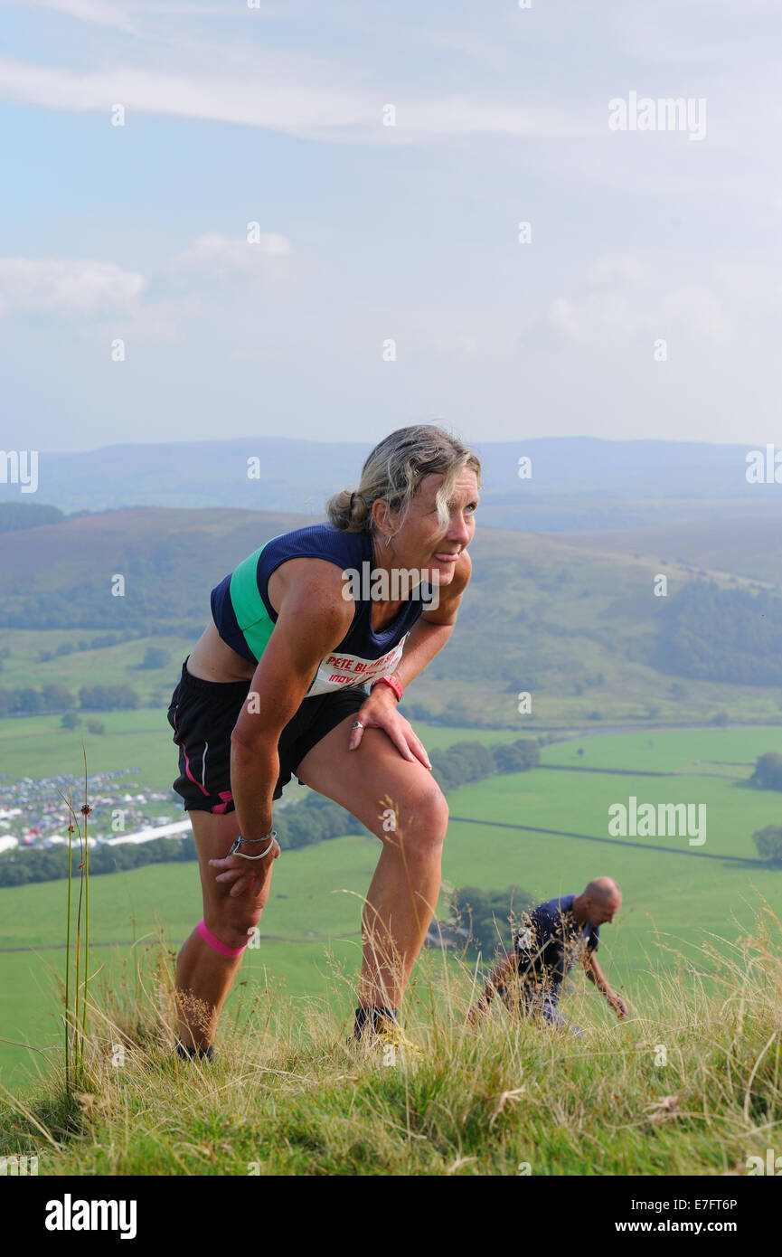 Lady Fell runner climbing a steep hill in a fell race at a country show Stock Photo