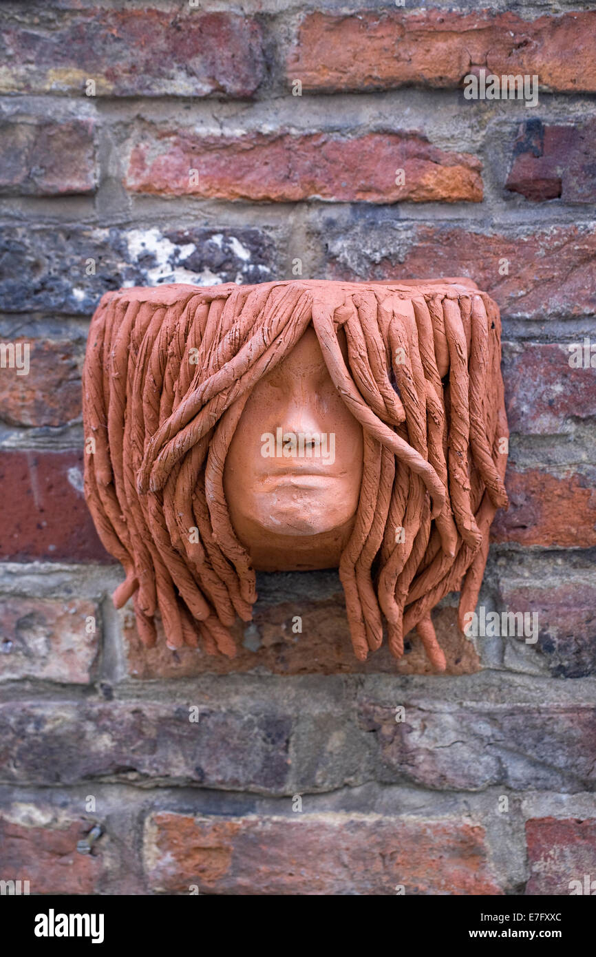 Terracotta planter on a brick wall. Stock Photo