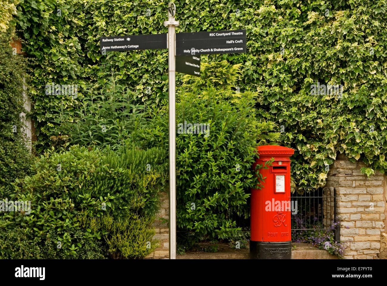 Red post box and ornate fingerpost sign in the centre of Stratford upon Avon. Stock Photo