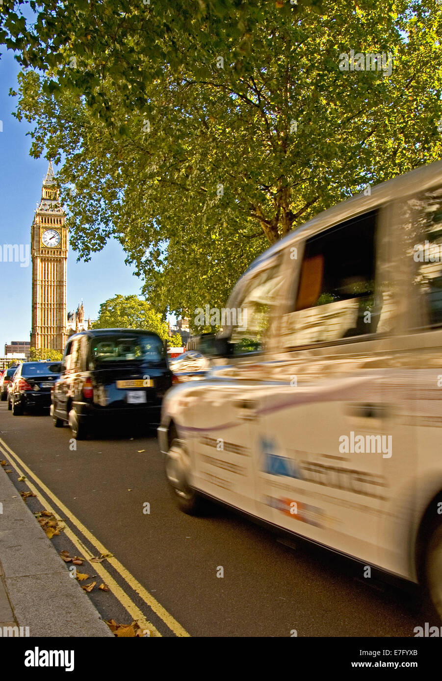 Iconic London taxi cabs approach Big Ben and Parliament Square, Westminster, London. Big Ben is currently undergoing restoration. Stock Photo