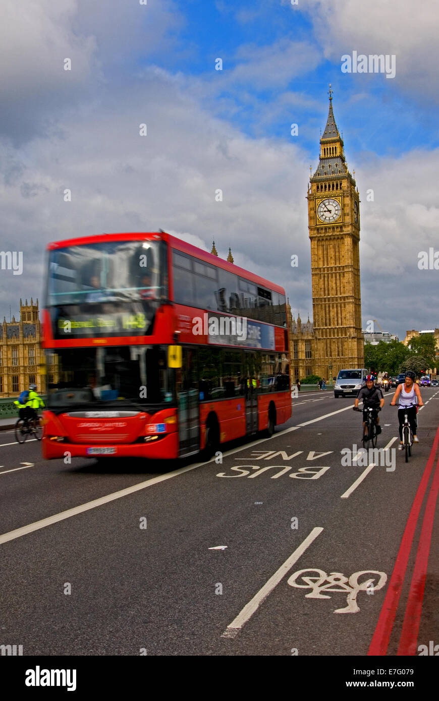 A red double decker London bus, and cyclists cross Westminster Bridge over the River Thames with Big Ben in the background. Stock Photo