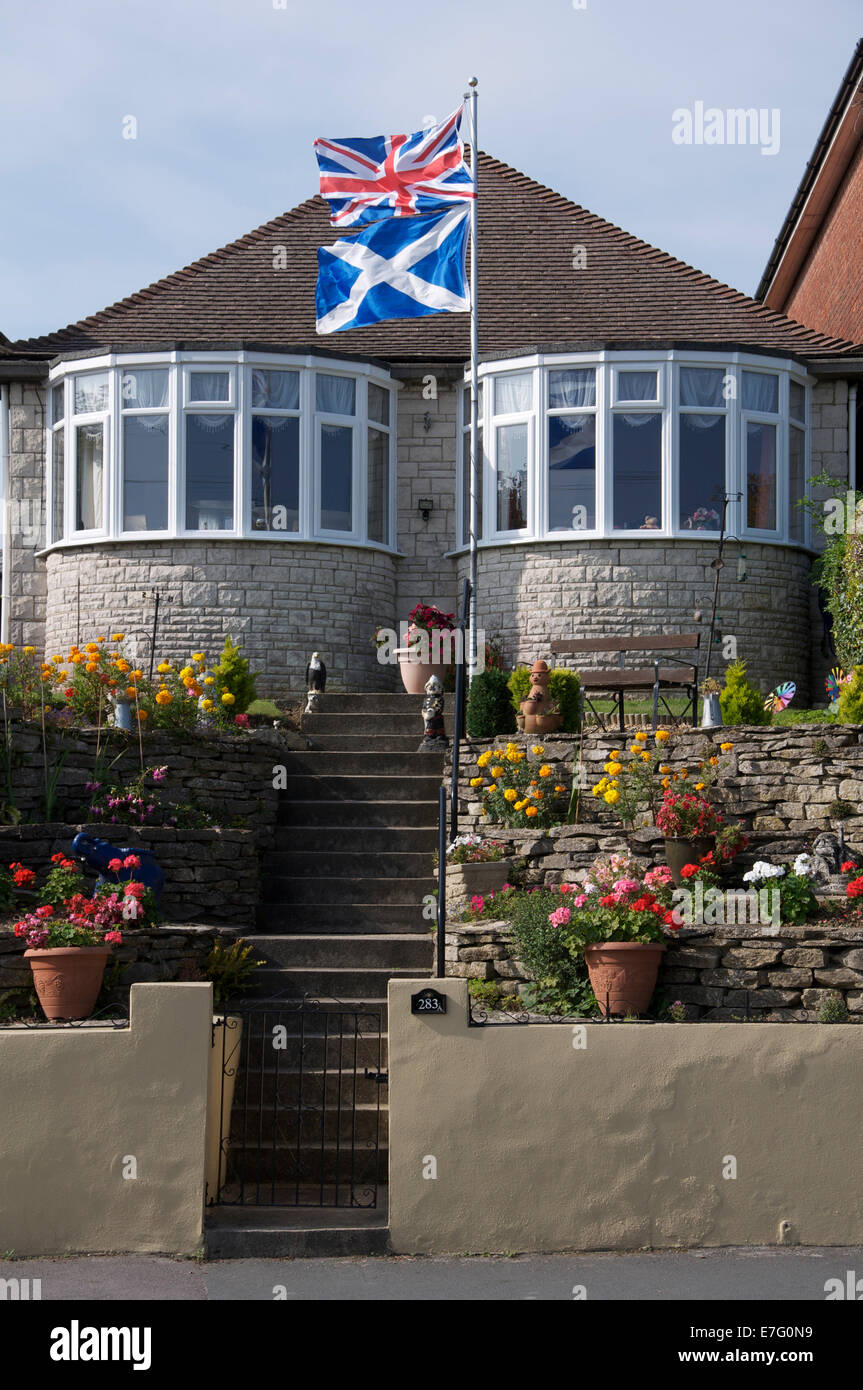 United Kingdom flags. The Union Jack and Scottish Saltire fly above a bungalow in England during the 2014 Scottish independence referendum campaign. Stock Photo