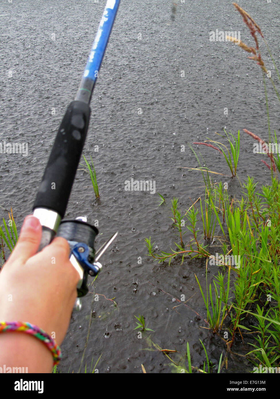 Girl fishing in heavy rain Stock Photo Alamy