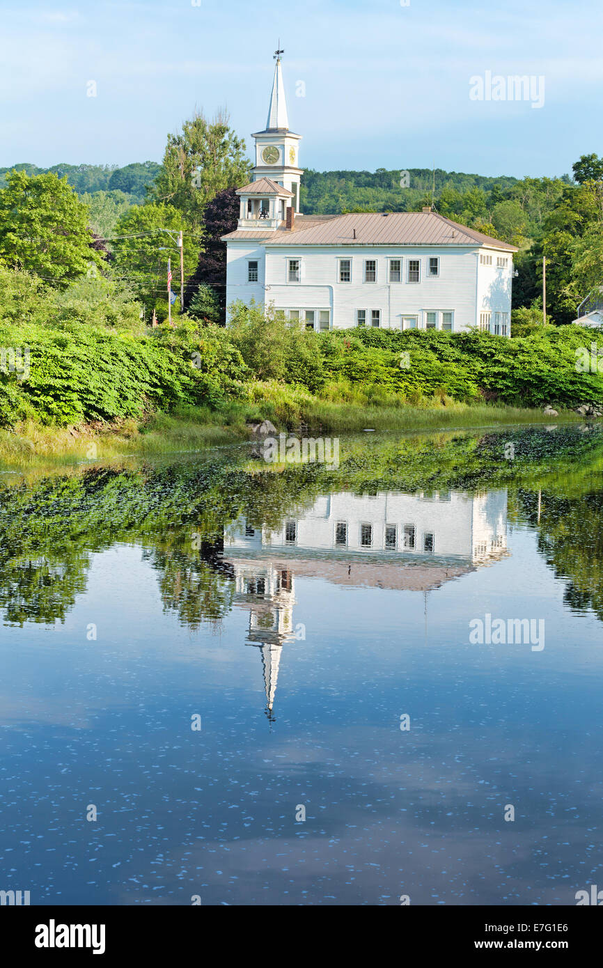 A reflection of a spired church and bell tower building on rippling water in Frankfort, Maine. Stock Photo