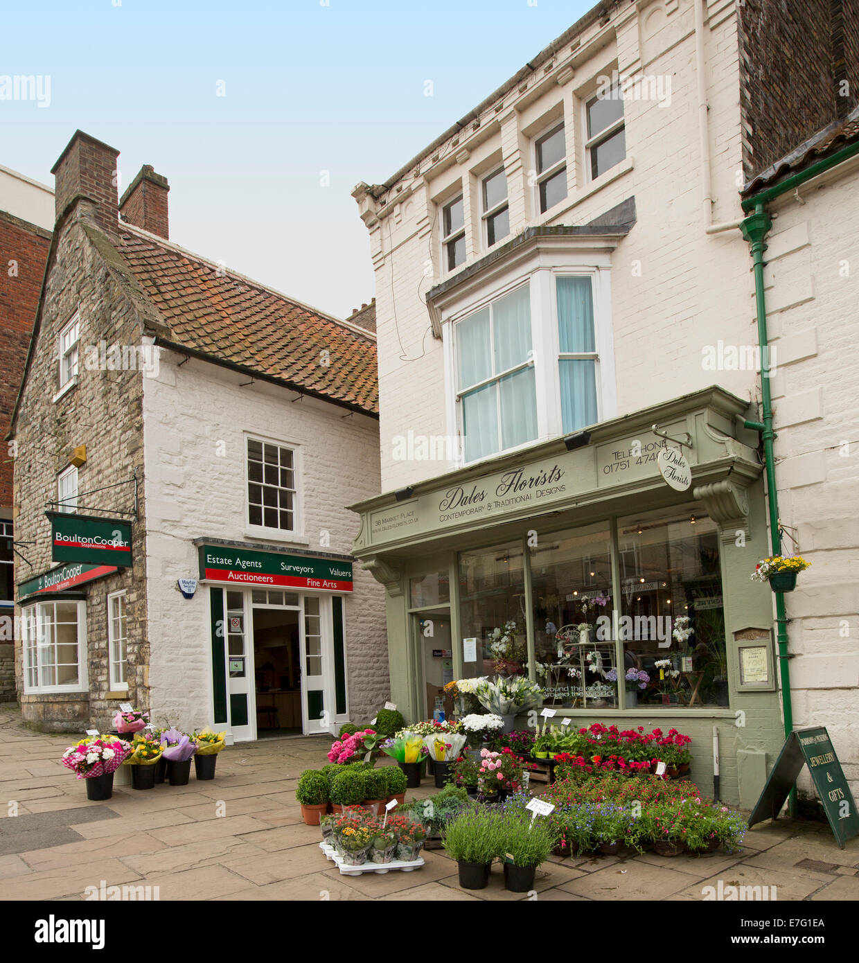Florist's shop with cut flowers and pots of colourful flowering plants on pavement in English village of Pickering Stock Photo