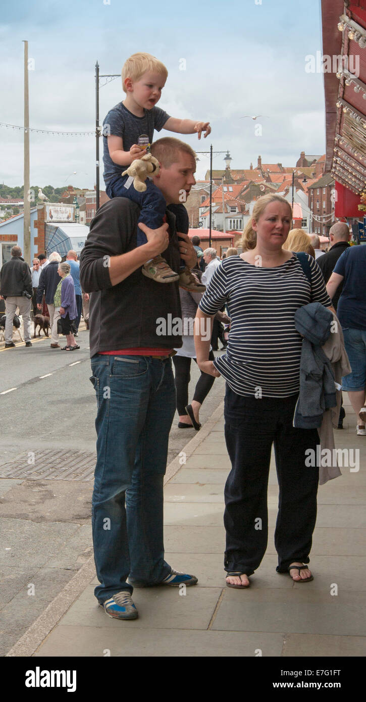 Young couple with father carrying young son on his shoulders, at English seaside town Whitby Stock Photo