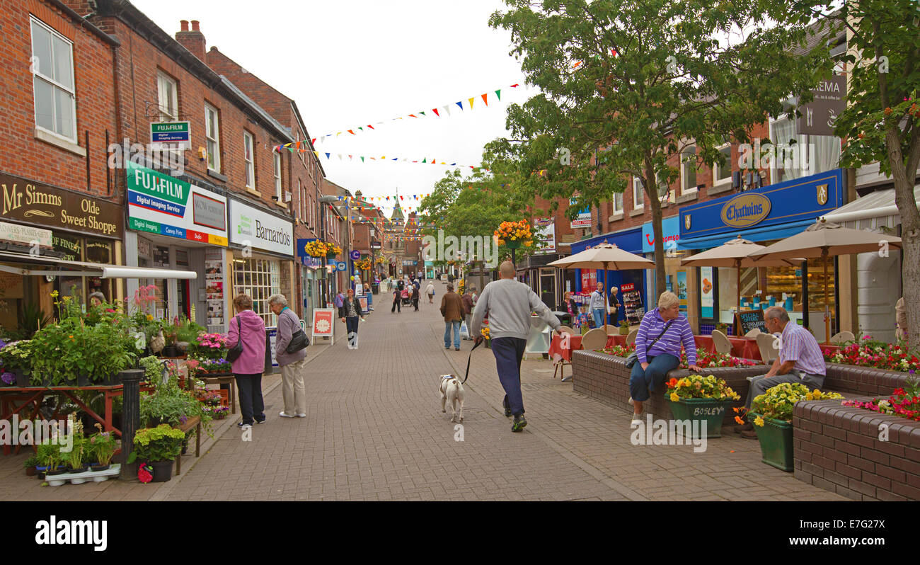 Pedestrian mall with shoppers browsing at stalls and colourful displays of flowers  in English town of Congleton Stock Photo