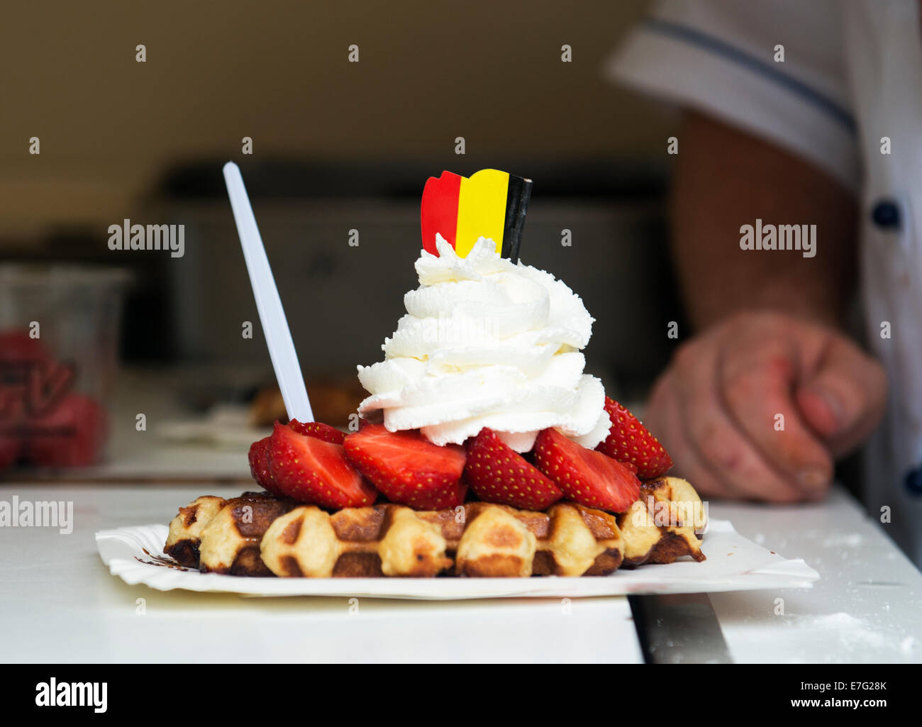 Belgian waffle topped with strawberries and whipped cream and decorated ...
