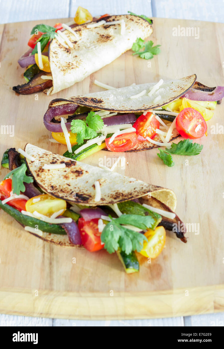 Tacos filled with roasted portobello mushrooms, zucchini, purple onions