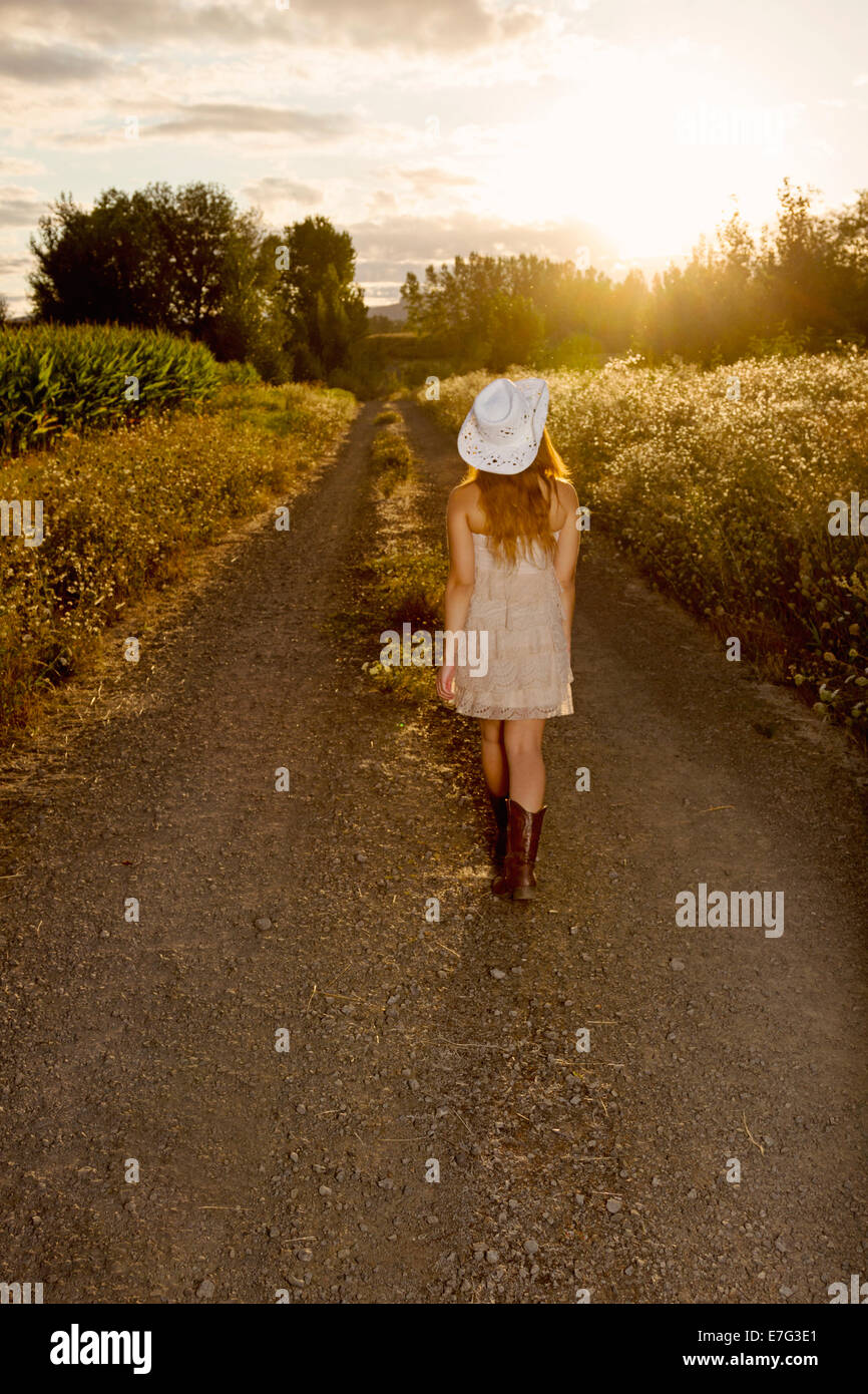 Beautiful country girl walking towards the sunset Stock Photo Alamy