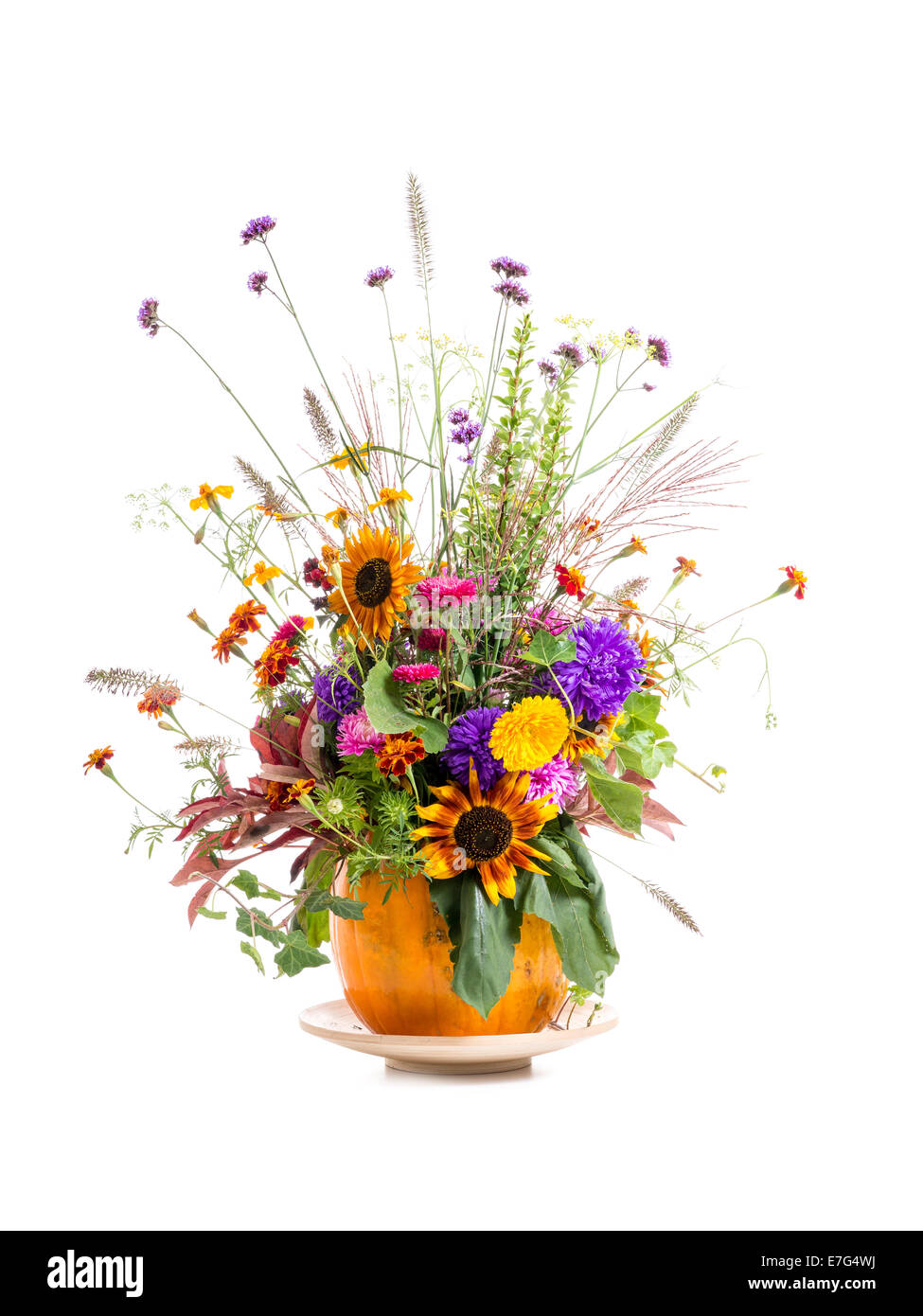 Wild flowers bouquet in carved pumpkin vase over white background Stock Photo