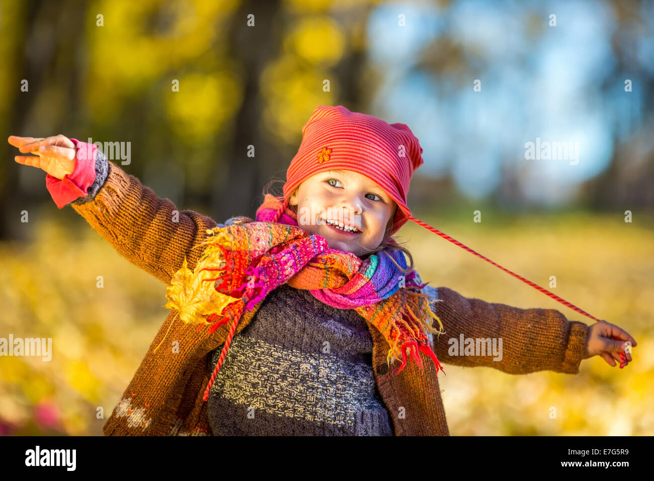 Happy little girl playing in the autumn park Stock Photo - Alamy