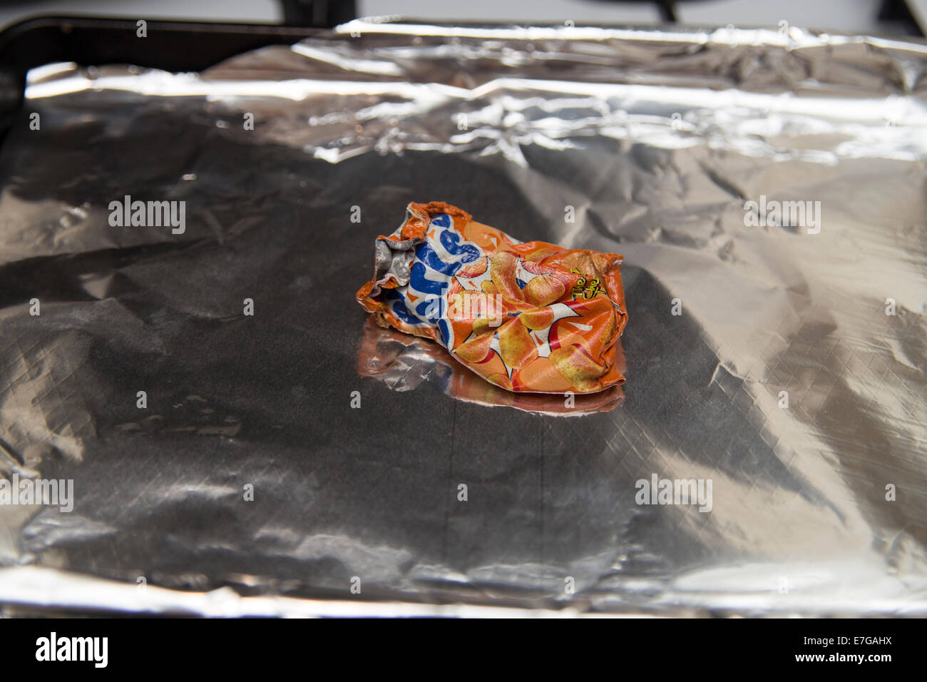 Shrinking a crisp packet in the oven, childhood craze from the 1980s, Stock Photo
