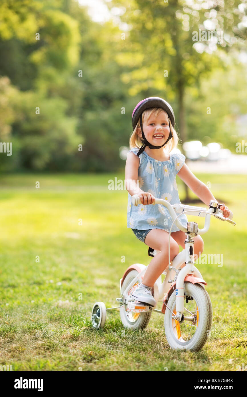Baby Rider Outside Portrait of happy baby girl riding bicycle outdoors in park Stock Photo ...