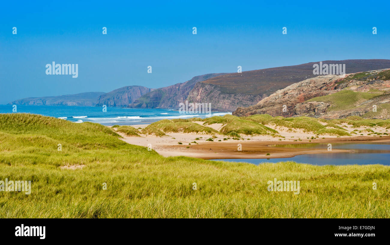 SANDWOOD BAY SEA AND CLIFFS  SUTHERLAND SCOTLAND AND SANDWOOD LOCH SURROUNDED BY SEA GRASSES Stock Photo