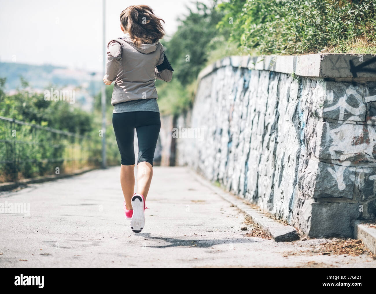 Fitness young woman jogging in the city park. rear view Stock Photo - Alamy