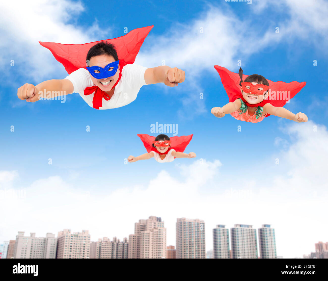 superman and daughters  flying in the sky with buildings background Stock Photo