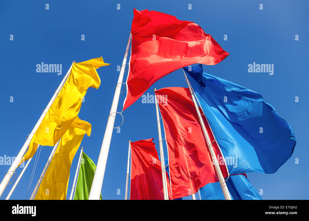 Colorful flags waving on blue sky background Stock Photo - Alamy