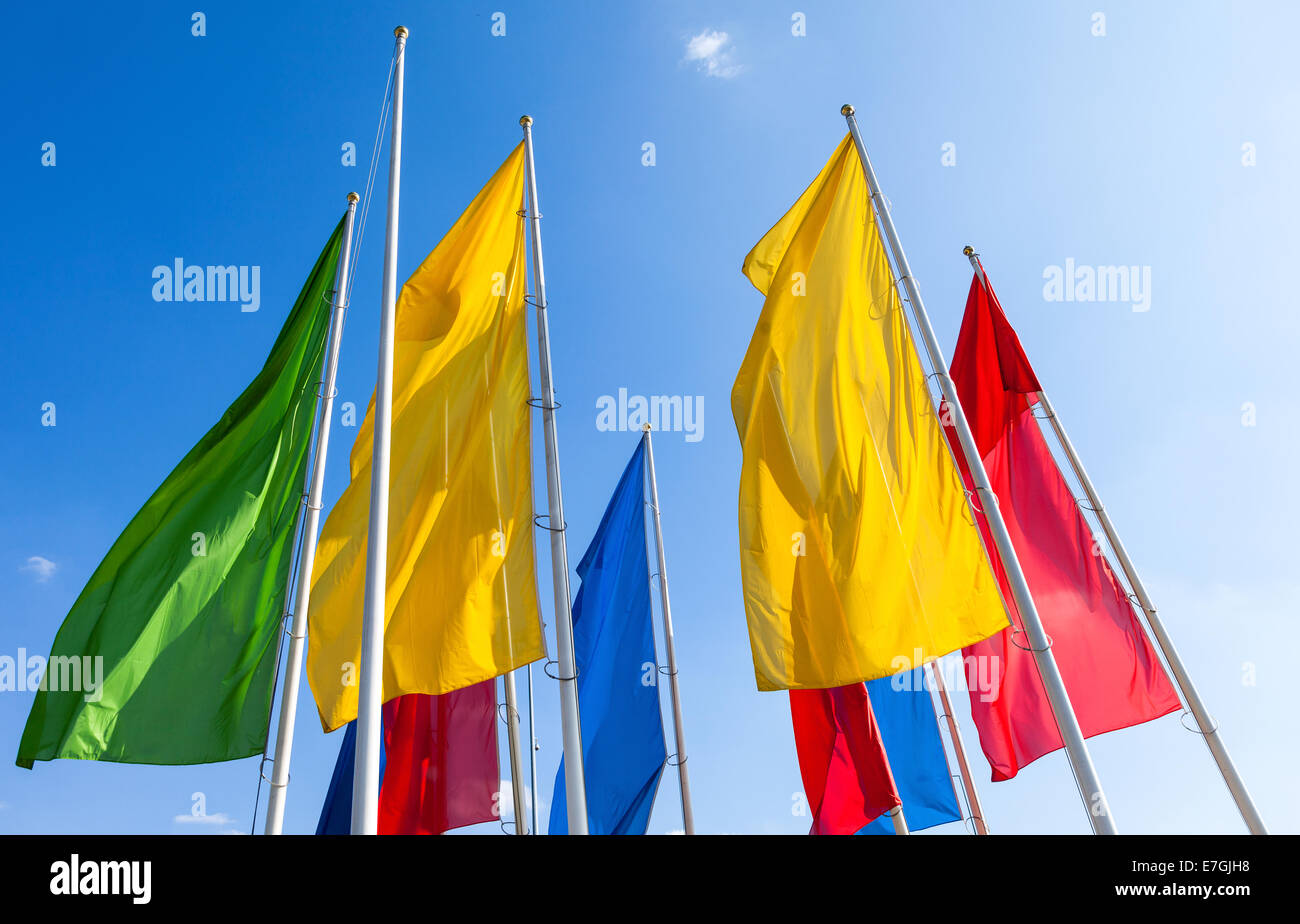 Colorful flags waving on blue sky background Stock Photo - Alamy