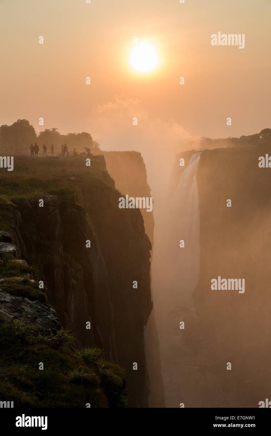 Victoria Falls sunset with tourist in the cliff Stock Photo