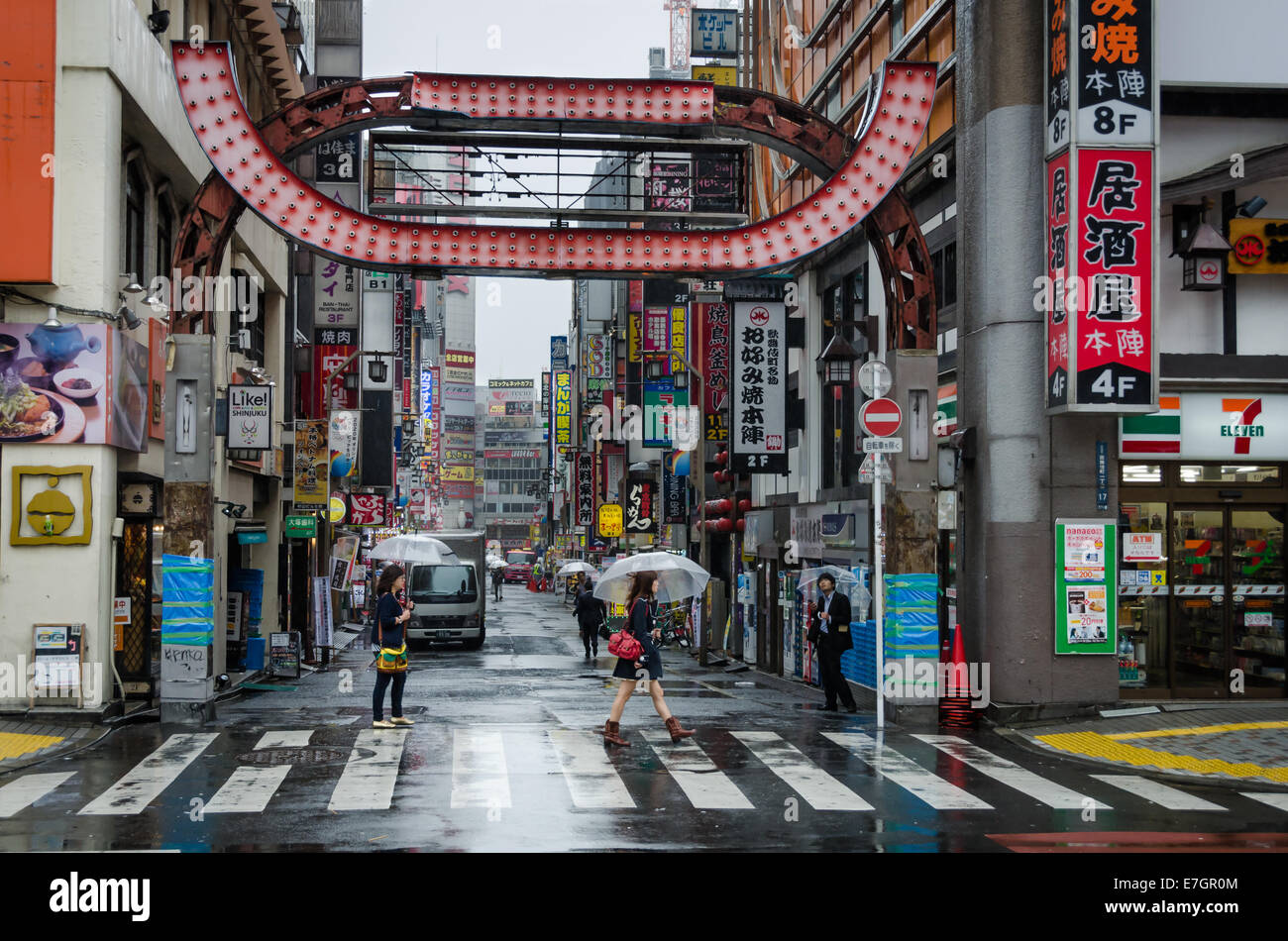 People walking under the rain in Kabukicho, red-light district of Shinjuku, Tokyo, Japan Stock Photo