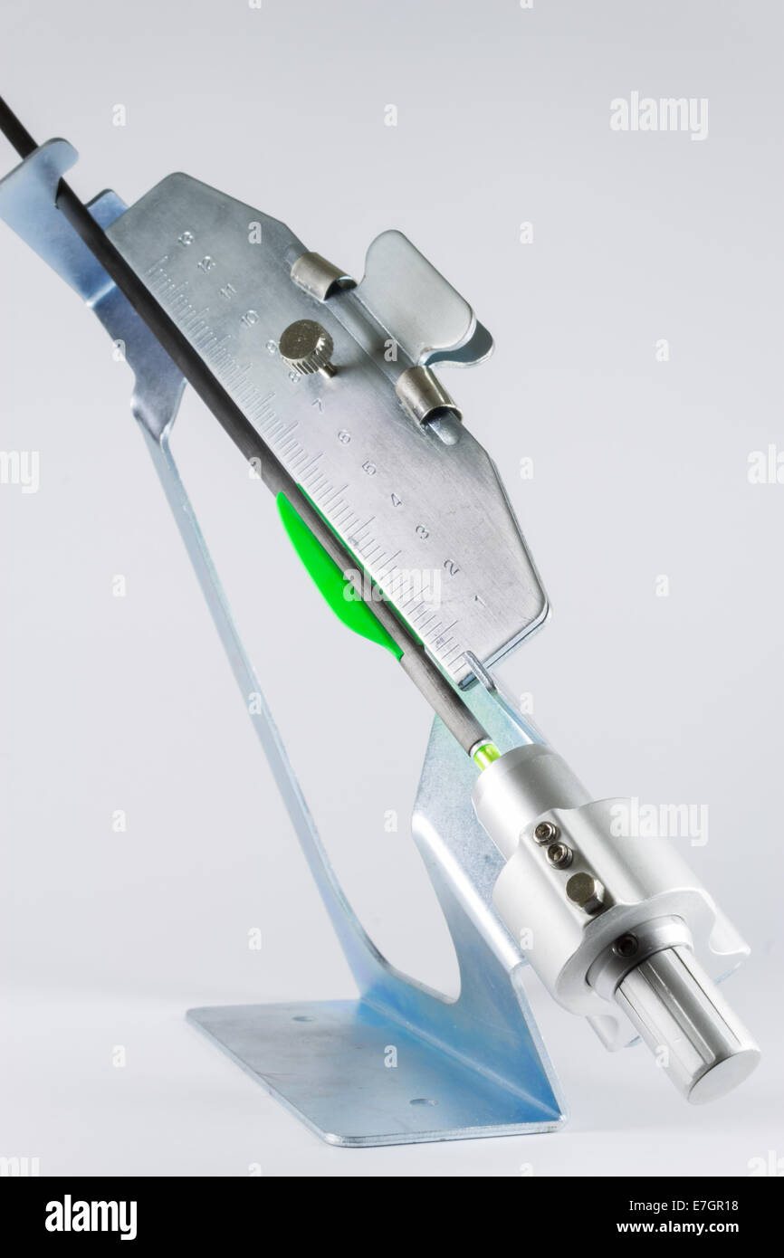Metal fletcher machine with thin competition target arrow in grip. Stock Photo