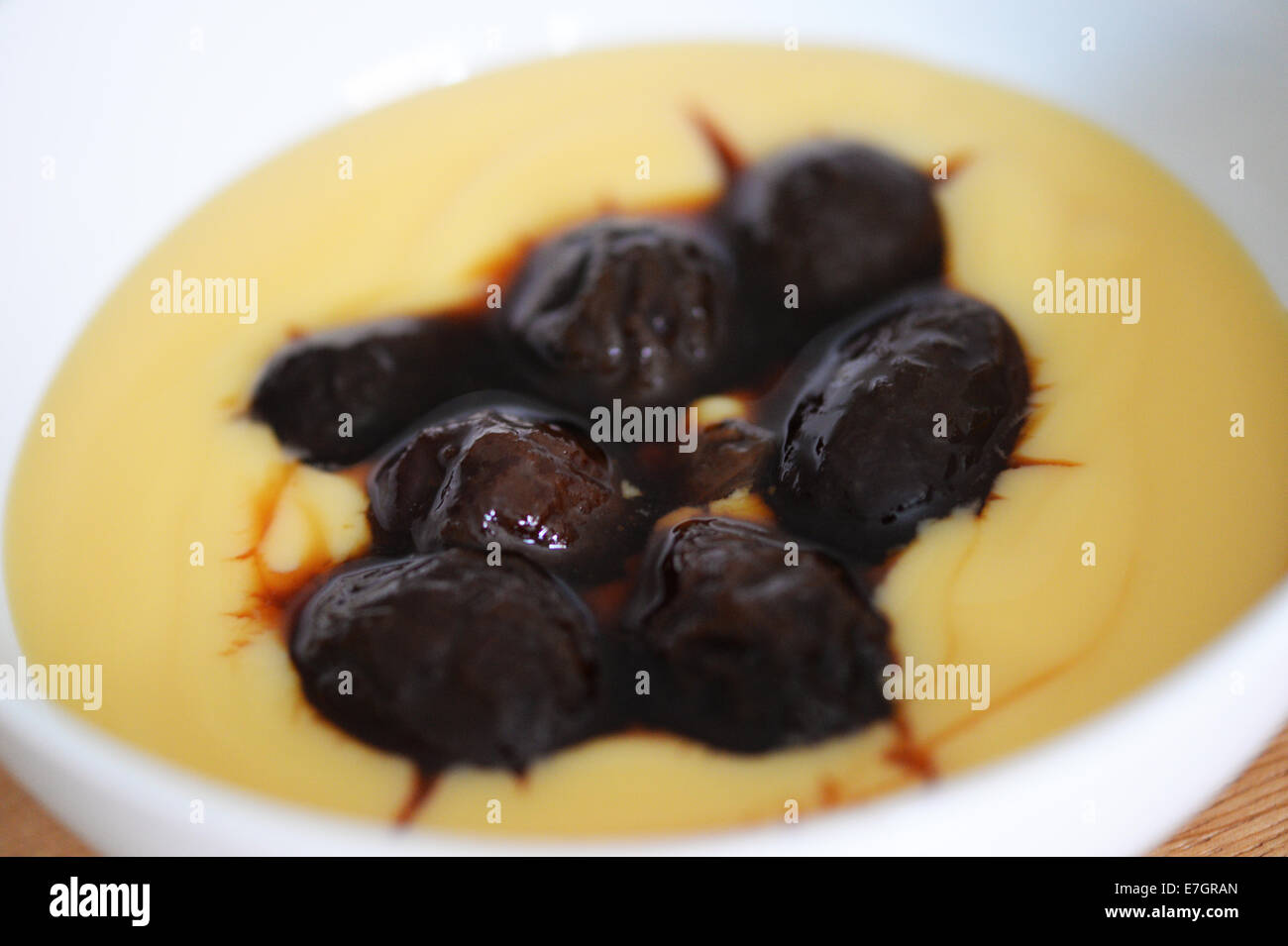 Prunes and custard desert Stock Photo Alamy
