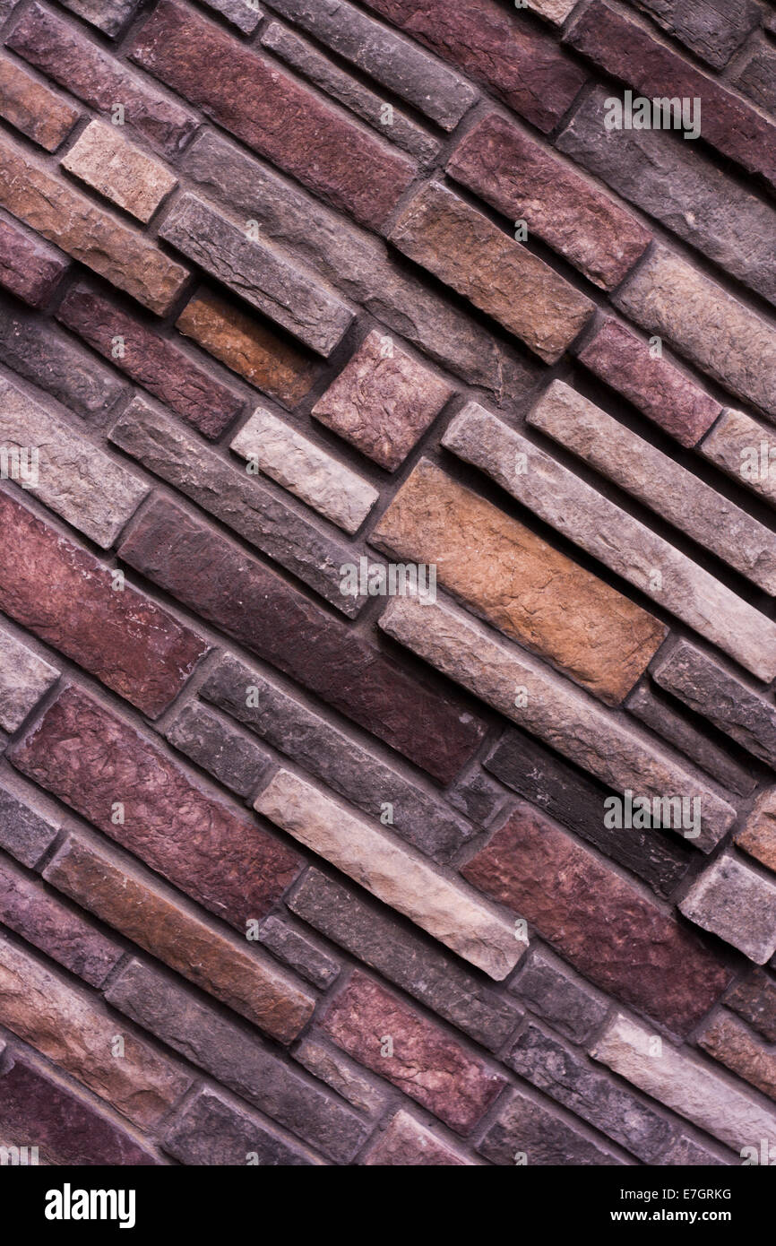 Brick in the Wall is a wall of irregular sized bricks. Stock Photo