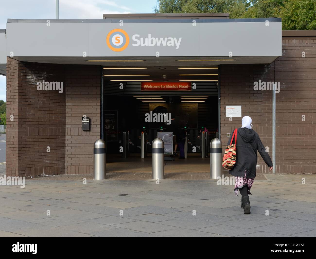 A woman entering Shields Road subway station in Glasgow Stock Photo