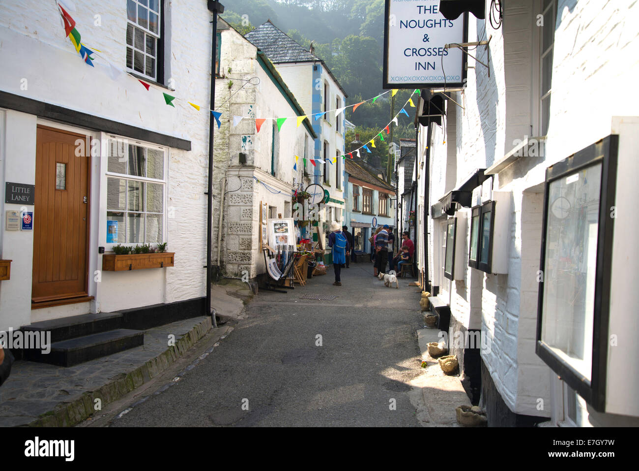 Narrow road with shops and inn sign in traditional fishing village, Cornwall, England 2014 Stock Photo