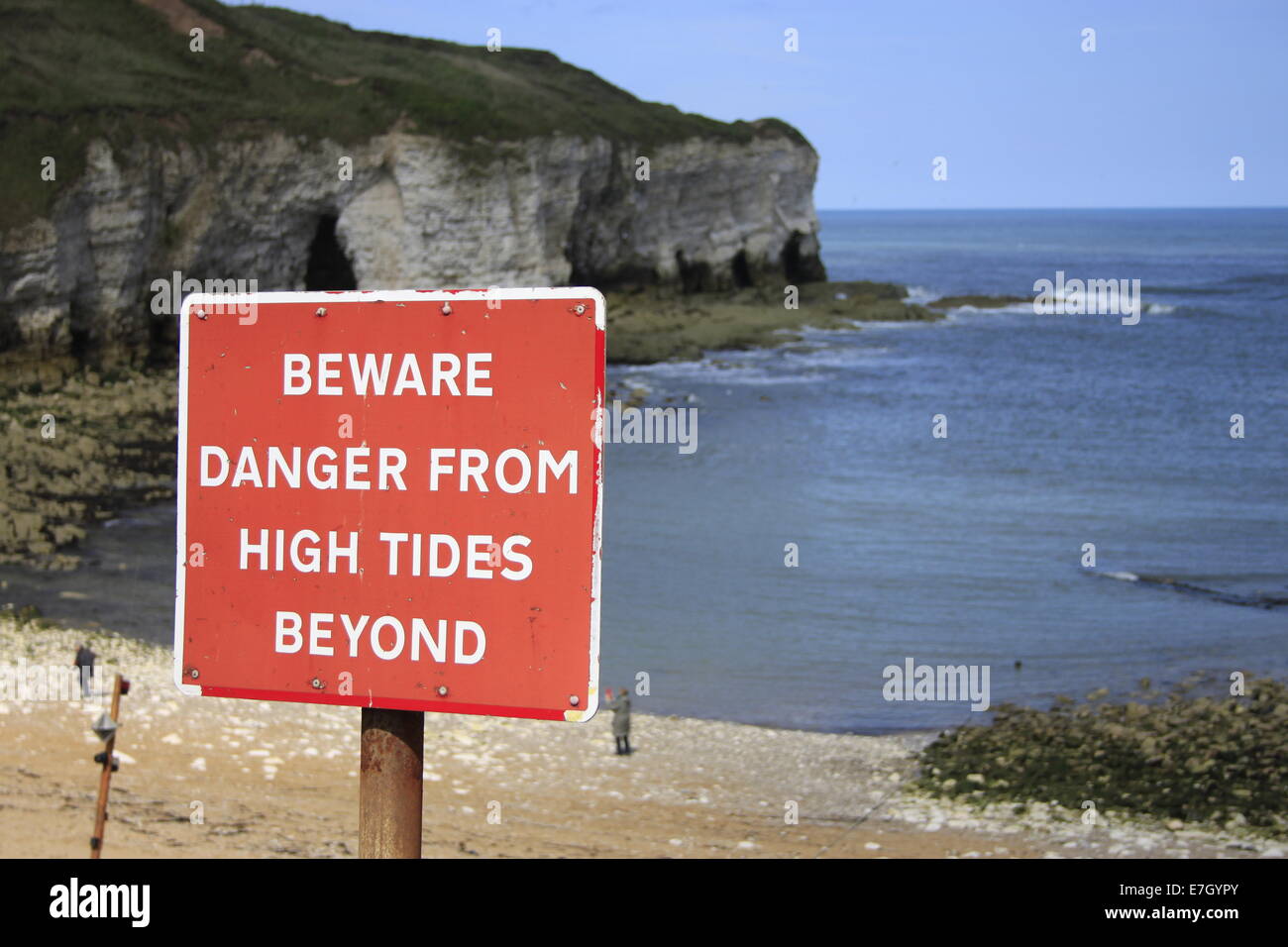 View of beach and cliff with 'Beware Danger from High Tides beyond' at Flamborough, East Yorkshire. Stock Photo