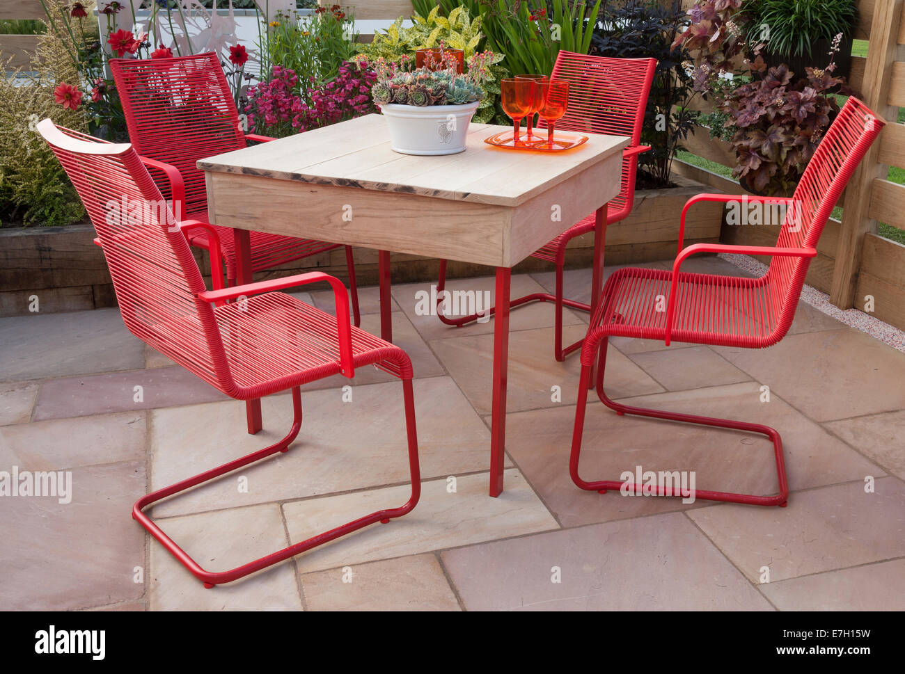 Garden - The Narrows - stone paved patio with table and red chairs plant pot with sempervivum - Designer - Pip Probert - Stock Photo