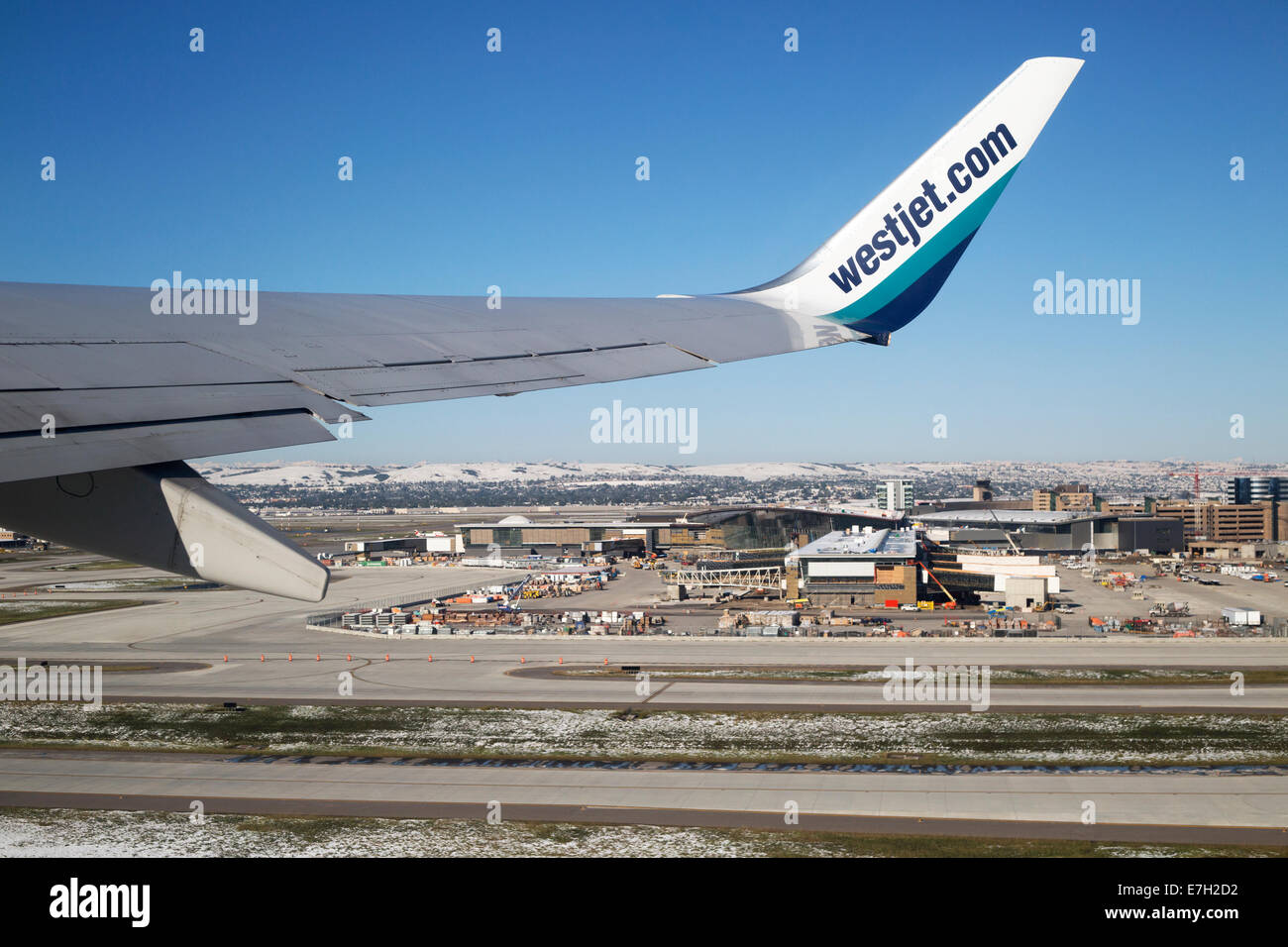 Passenger view of Westjet wing taking off over Calgary Airport Stock