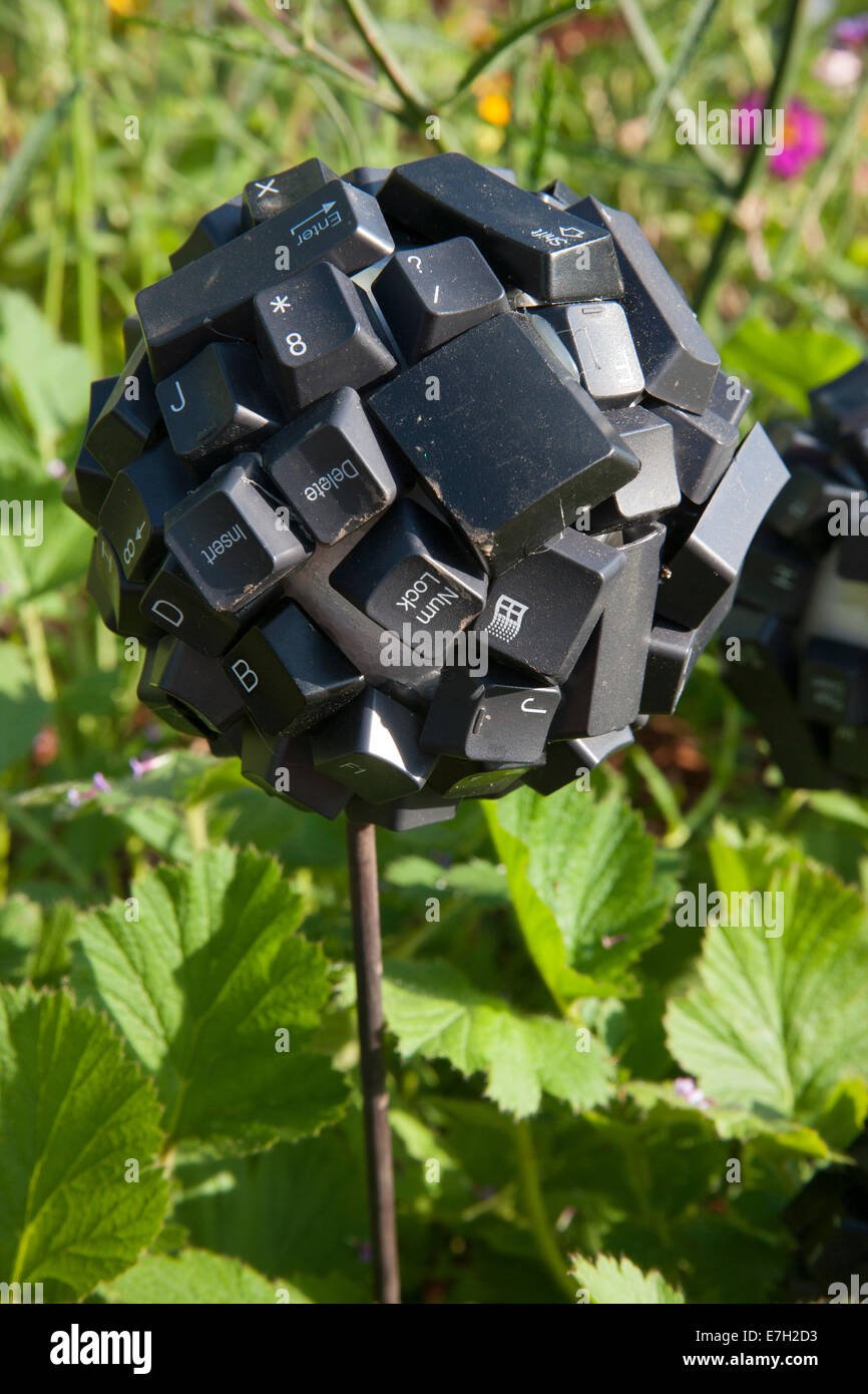 Sustainable eco friendly garden ball ornament sculpture made from recycled reused repurposed materials computer keyboard keys eco use UK Stock Photo