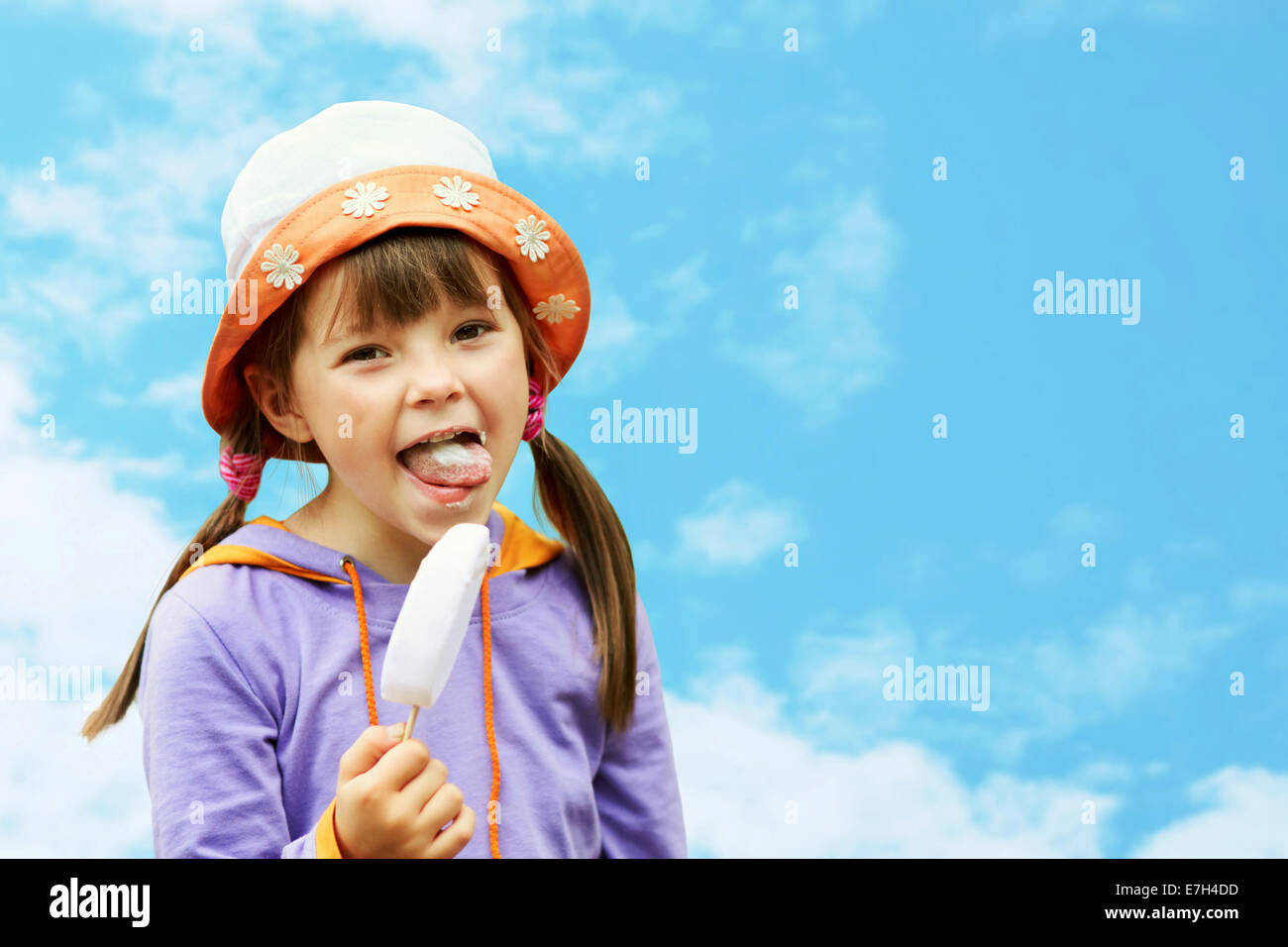little girl in hat eating ice cream on a background of sky Stock Photo ...