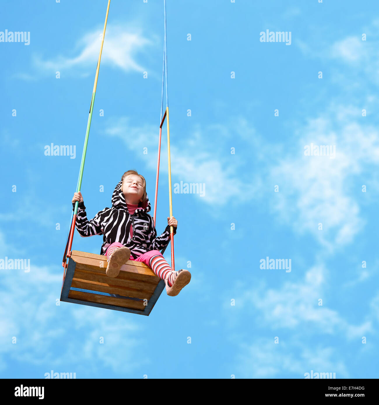 happy little girl on a swing on sky background Stock Photo - Alamy